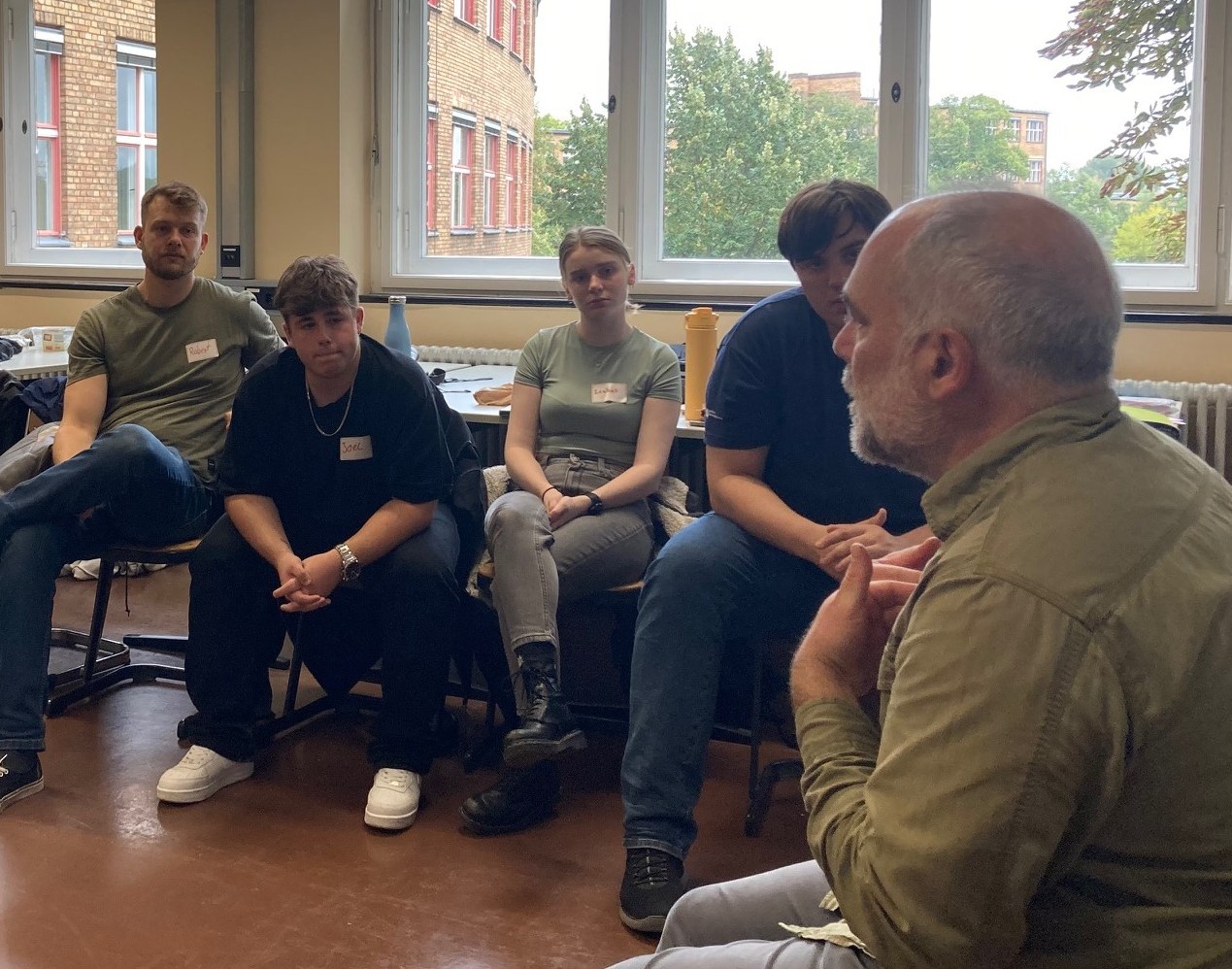 Deutsche Gesellschaft e. V., Gruppenleiter spricht zu einer Gruppe Jugendlicher